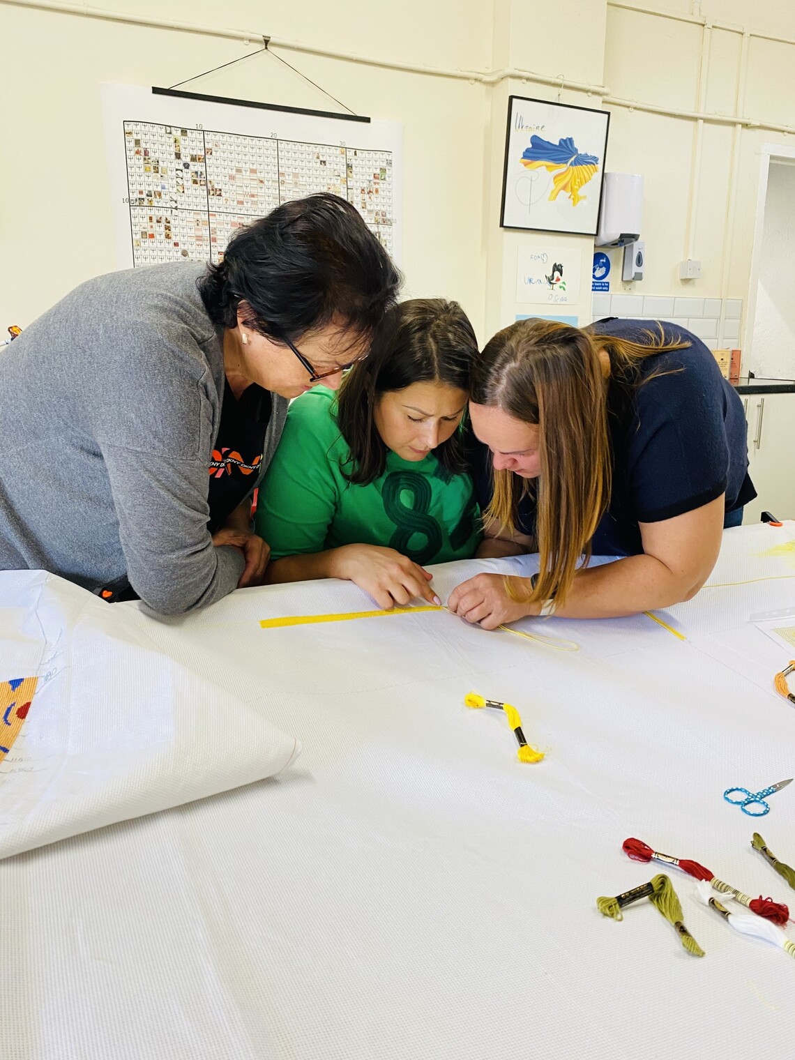 Women stitching together a big tapestry