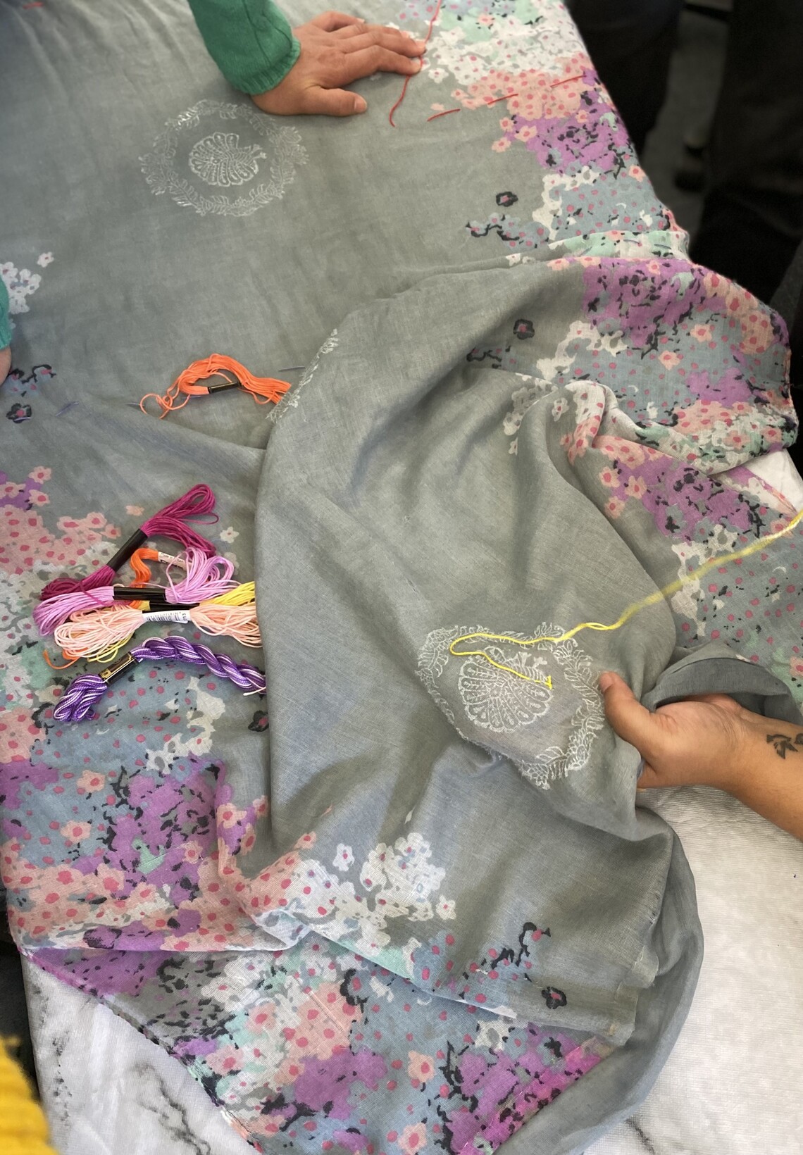 a women embroidering Kantha stitch on scarves