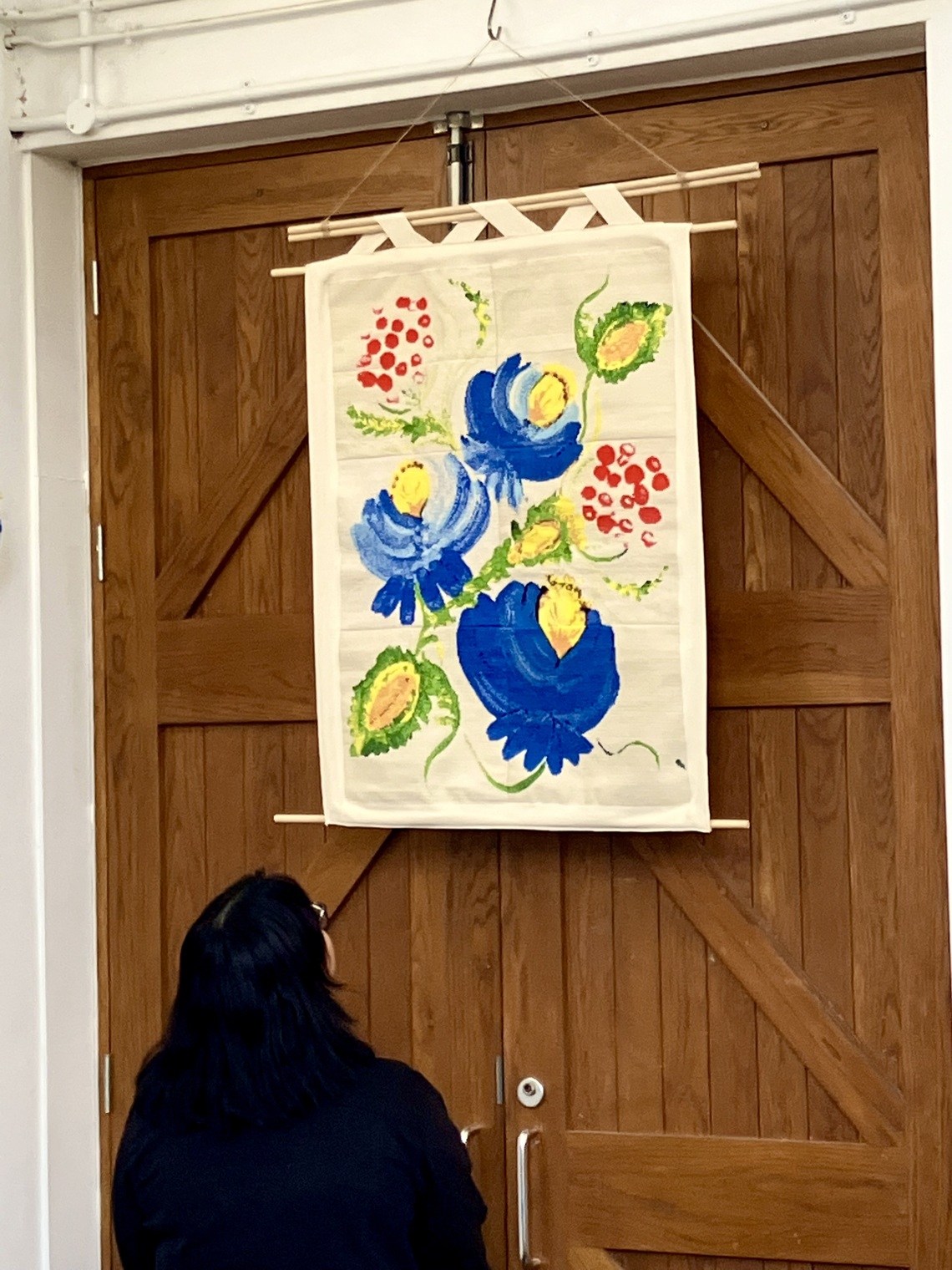 Girl looking at a tapestry of blue flowers