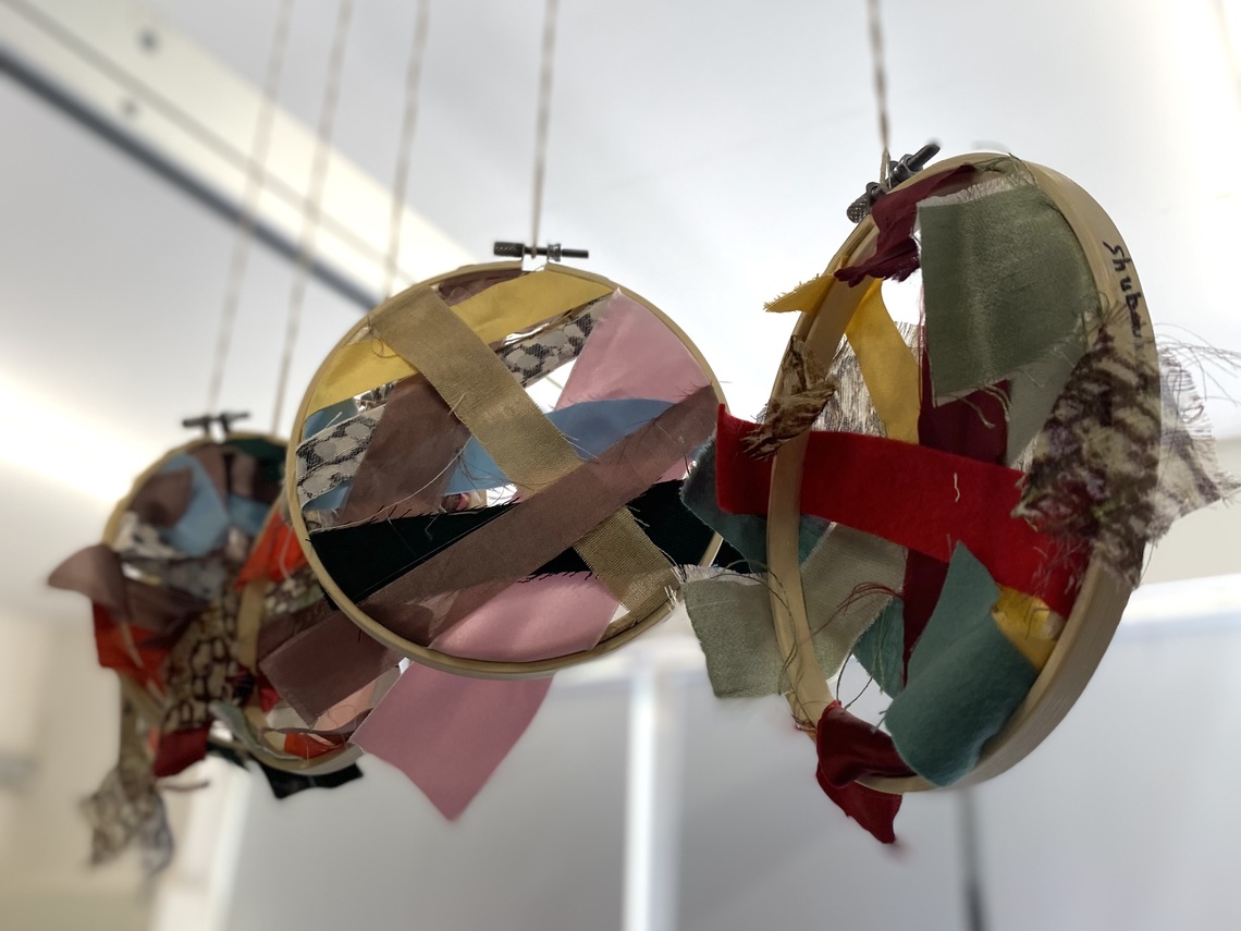 Mixed fabric scraps arranged creatively and displayed in hoops