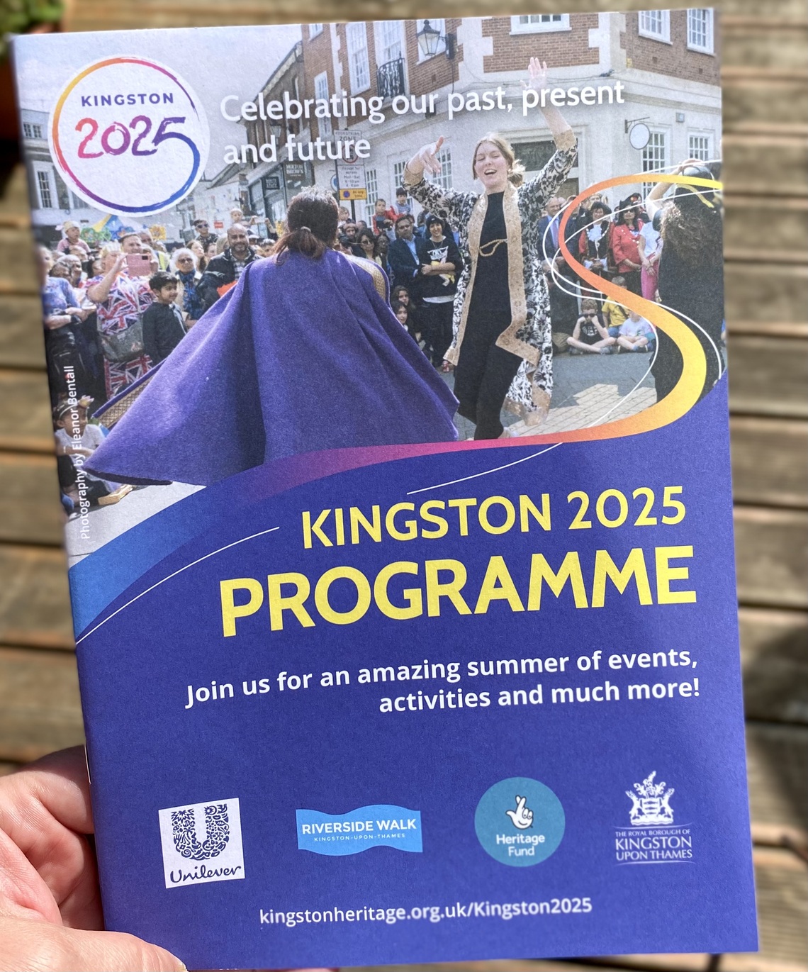 A hand holding a programme booklet 